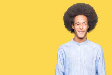 Afrikalı-Amerikalı genç afro saçlı seksi bir ifadeyle, neşeli ve mutlu yüzünü kameraya bakarak göz kırpıyor.