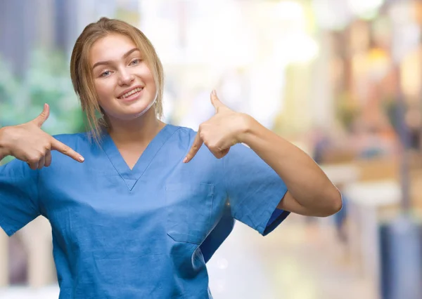 年轻的高加索护士妇女穿外科医生制服在孤立的背景看起来自信与微笑在脸上 指着自己与手指自豪和快乐 — 图库照片