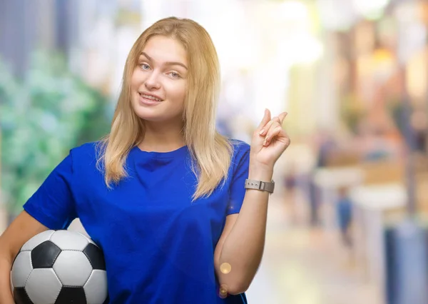 Junge Kaukasische Frau Hält Fußballball Über Isoliertem Hintergrund Und Zeigt — Stockfoto