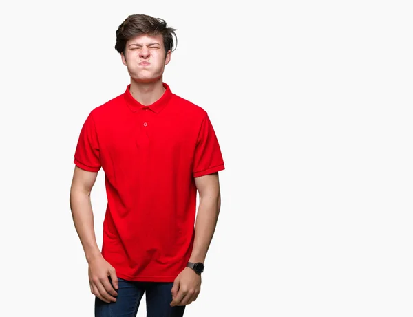 変な顔で頬に息を切らし孤立の背景に赤い シャツを着ての若いハンサムな男 クレイジー式空気で膨らませ口 — ストック写真