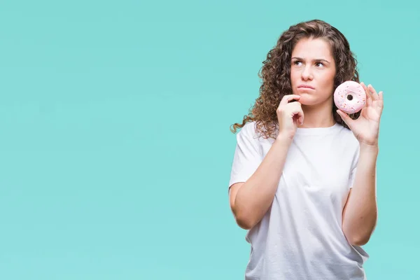 Joven Morena Comiendo Donut Sobre Fondo Aislado Cara Seria Pensando —  Fotos de Stock