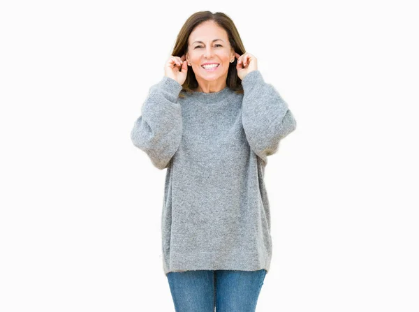 美丽的中年妇女穿着冬季毛衣在孤立的背景微笑拉耳朵用手指 有趣的手势 试听问题 — 图库照片