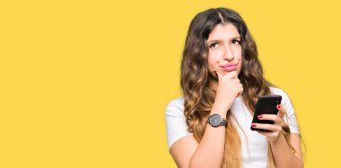 Fikir Smartphone ciddi bir yüz düşünme soru hakkında çok kullanan Genç Yetişkin kadın karışık