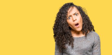 Şüpheci ve alaycı, arayan genç güzel kadın kıvırcık saçlı şok karşısında, gri kazak giyen açık ağız ile şaşırttı