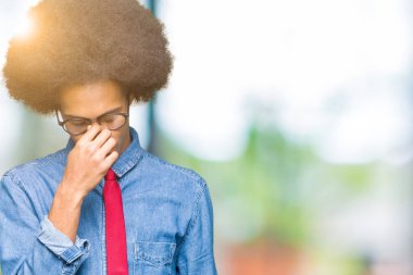 Gözlük ve kırmızı giyen afro saçlı genç Afro-Amerikalı iş adamı bağla yorgun sürtünme burun ve göz yorgunluğu ve baş ağrısı hissediyor. Stres ve hayal kırıklığı kavramı.