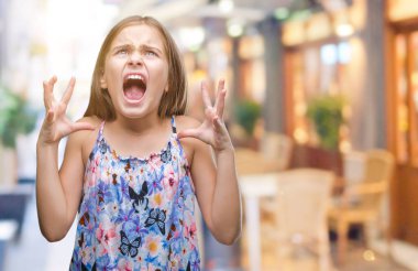 Çılgın ve kızgın bağırarak ve agresif ifade ve silah kaldırdı bağırmaya izole arka plan üzerinde renkli elbise genç güzel kız. Hayal kırıklığı kavramı.