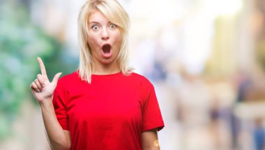 Başarılı fikirle izole arka plan işaret parmağı üzerinde kırmızı t-shirt giyen genç güzel sarışın bir kadın. Çıktıktan ve mutlu. Bir numara.