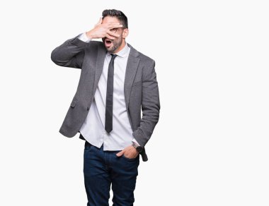 Mahcup ifadeyle parmaklarımın arasından seyir yüz ve gözler el ile kapsayan şok izole arka plan bakmak üzerinde genç yakışıklı iş adamı.