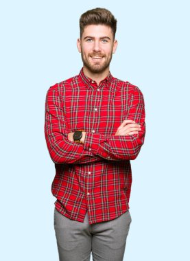 Genç yakışıklı mutlu yüz çapraz kollu kameraya bakarak gülen adam. Olumlu bir kişi.