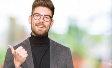 Hareketi el ile mutlu yaşasın yapıyor gözlüklü genç yakışıklı iş adamı. Kameraya bakarak başarı gösteren ile ifade onaylama.