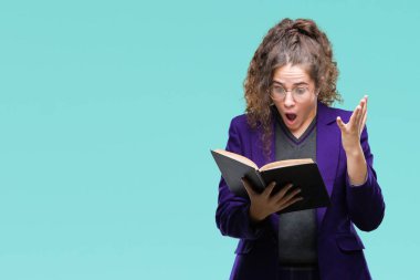 Okul bir kitap okuma üniforma giyen genç esmer öğrenci kız kocaman bir gülümseme ile çığlık zaferini kutluyor ve ellerini kaldırdı arka plan çok mutlu ve heyecanlı, kazanan ifade izole