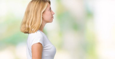 İzole arka tarafına, seyir üzerinde rahat beyaz t-shirt giyen güzel genç kadın dinlenmek doğal yüz emin gülümseme ile pozuyla profili.