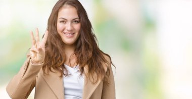 Parmakları ile kendinden emin ve mutlu gülümseyerek süre güzel artı boyutu genç kadın giyiyor kış ceket ve yukarıyı gösteren izole arka plan üzerinde üçüncüsü.