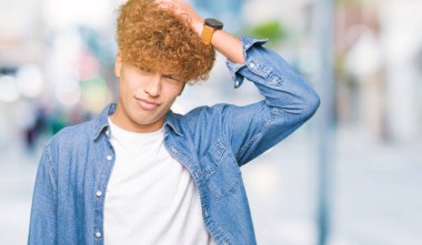 Afro saçlı kot ceket giyen genç yakışıklı adam yanıltır ve soru hakkında merak ediyorum. Şüphe, kafasına el ile düşünme ile belirsiz. Dalgın kavramı.