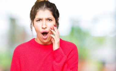 Kırmızı kazak ve çörek korkuyor ve şok sürpriz ifade, korku ve heyecan yüz ile giyen genç güzel kadın.