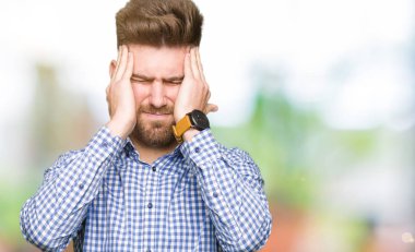 Genç yakışıklı bussines adam çünkü umutsuz ve stresli baş ağrısı acı acı ve migren. Ellerini kafasına.