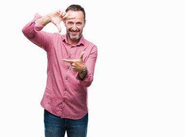 Orta yaş elle yapma çerçeve ve parmakları ile mutlu yüz gülümseyen izole arka plan üzerinde ağarmış komuta sizde. Yaratıcılık ve Fotoğrafçılık kavramı.