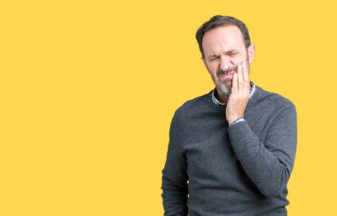 Yakışıklı orta yaş komuta sizde diş ağrısı veya dişlerde dişlerle ilgili hastalık nedeniyle ağız acı ifadesi ile el ile dokunmak izole arka plan üzerinde bir kazak giyiyor. Diş hekimi kavramı.