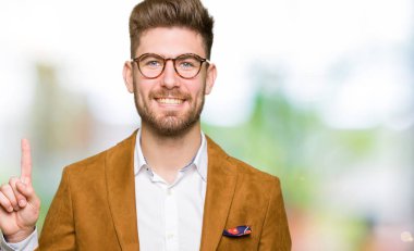 Gösterilen ve parmak gülümseyen süre bir numara ile kendinden emin ve mutlu yukarıyı gözlüklü genç yakışıklı iş adamı.