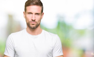 Yakışıklı adam rahat beyaz t-shirt giyen depresif ve kızgın ve korkmuş ağlıyor sıkıntı için endişeleniyorum. Üzgün ifade.