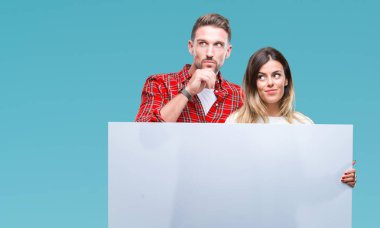 Soru, çok karışık fikir hakkında düşünme bir arada boş afiş izole arka plan üzerinde ciddi tutan genç bir çift yüz