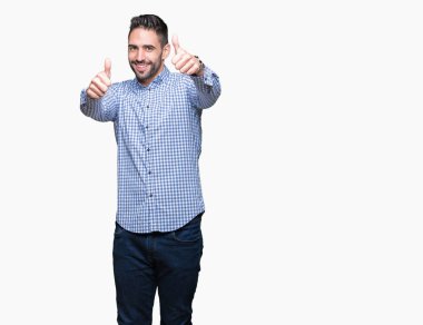 Yakışıklı delikanlı el ile pozitif jest yapıyor onaylama izole arka plan üzerinde başparmak gülümseyen ve başarı için mutlu. Kamera, kazanan jest arıyorsunuz.