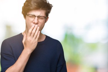 Yakışıklı delikanlı izole arka plan üzerinde gözlük el ağzıyla kapsayan yorgun esneme sıkılmış. Restless ve uyku hali.