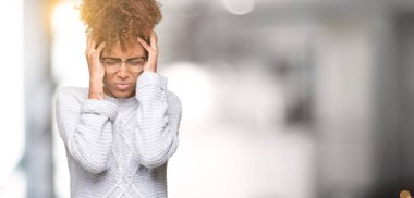 Çünkü çaresiz ve stresli baş ağrısı acı izole arka plan üzerinde kış kazak giyen güzel genç Afro-Amerikan kadın ağrı ve migren. Ellerini kafasına.