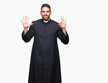 Genç Hıristiyan rahip gösterilen ve parmakları ile işaret izole arka plan üzerinde kendinden emin ve mutlu gülümseyerek süre sekiz numara.