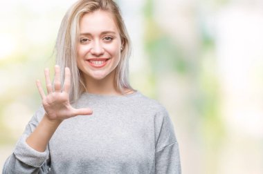 Genç Sarışın kadın gösterilen ve parmakları ile işaret izole arka plan yüzünden kendinden emin ve mutlu gülümseyerek süre beş numara.