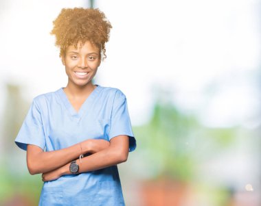 İzole arka plan mutlu yüz çapraz silah kameraya bakarak ile gülümseyen genç Afro-Amerikan doktor kadın. Olumlu bir kişi.