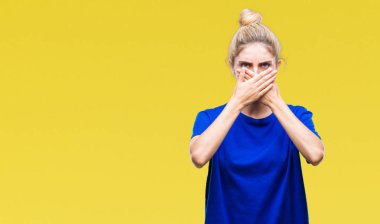 Üzerinde mavi t-shirt giyen genç güzel sarışın ve mavi gözlü kadın arka plan ağız hata için elleriyle kapsayan şok izole. Gizli kavramı.