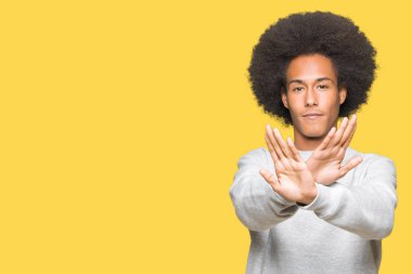 Sportif kazak ret ifade geçiş silah ve eksi işareti, kızgın surat yapıyor avuç içi afro saçlı genç Afro-Amerikan adam