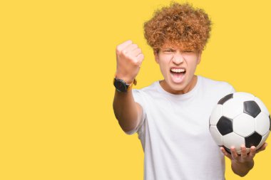 Yakışıklı delikanlı futbol futbol topu tutan rahatsız ve öfkeyle, çılgın ve yükseltilmiş eliyle diye bağıran öfke kavramı bağırarak boşa