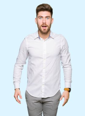 Genç yakışıklı iş adamı korkuyor ve sürpriz ifade, korku ve heyecan yüz ile şok.