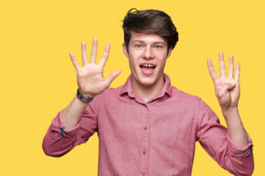 Genç yakışıklı iş adamı gösterilen ve parmakları ile işaret izole arka plan üzerinde numara 9 kendinden emin ve mutlu gülümseyerek süre.