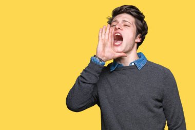 Genç yakışıklı zarif adam bağırıyor ve ağzı üzerinde el ile yan için çığlık izole arka plan üzerinde. İletişim kavramı.