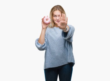 Açık eliyle dur işareti ile ciddi ve kendine güvenen ifade, savunma jest yapıyor izole arka plan üzerinde tatlı çörek yiyen genç kafkas kadın