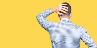 Mavi gözlü geriye düşünce hakkında şüphe ile kafasına el ile yakışıklı iş adamı