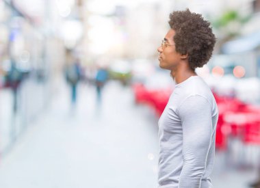 Afro Amerikalı adam giyen güneş gözlüğü izole arka tarafına, seyir üzerinde dinlenmek doğal yüz emin gülümseme ile pozuyla profili.