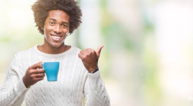 İşaret ve başparmak kadar mutlu yüz gülümseyen tarafı ile gösteren izole arka plan üzerinde kahve içme Afro Amerikalı adam