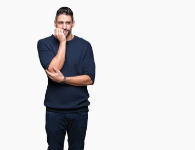 Genç yakışıklı adam stresli ve gergin ile izole arka plan üzerinde kazak giyen tırnak ısırma dudaklarından eller. Anksiyete sorunu.