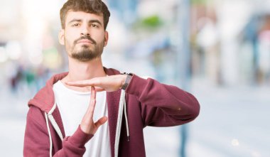 Yakışıklı delikanlı izole arka plan yapıyor zaman aşımı jest elle, sinirli ve ciddi bir yüz üzerinden