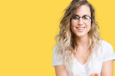 Güzel sarışın genç kadın gözlük izole üzerine gülen alma veya jest vererek birlikte el avuç içi ile arka plan. Ayrı tutma ve koruma