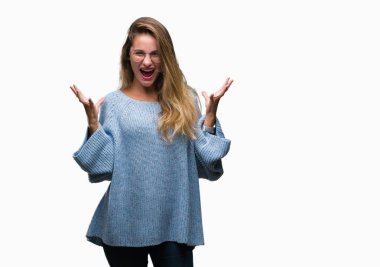 Genç güzel sarışın kadın giyiyor kazak ve gözlük kızgın ve silah ile başarı için deli kutluyor izole arka plan üzerinde kaldırdı ve heyecanlı çığlık gözler kapalı. Kazanan kavramı