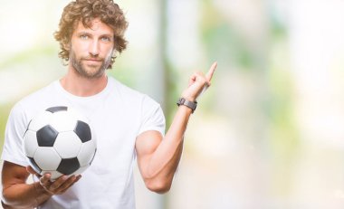 Futbol futbol topu izole arka plan üzerinde çok mutlu el ve parmak ile tarafına işaret tutan Latin asıllı yakışıklı modeli