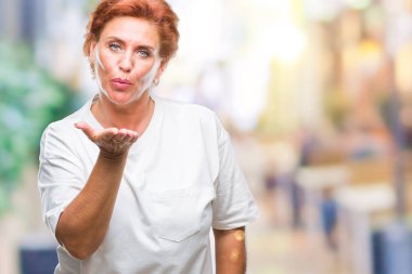 Bir öpücük el ile güzel ve seksi olmak hava üfleme kamera bakarak izole arka plan Atrractive üst düzey beyaz Kızıl saçlı kadın. Aşk ifade.