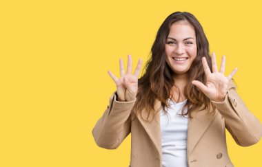 Parmakları ile dokuz kendinden emin ve mutlu gülümseyerek süre güzel artı boyutu genç kadın giyiyor kış ceket ve yukarıyı gösteren izole arka plan üzerinde numara.