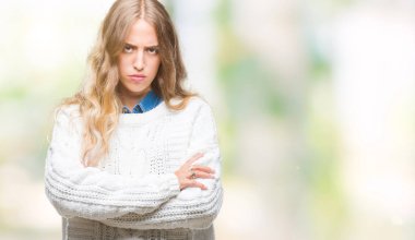 İzole arka plan şüpheci ve sinir, onaylamayan ifade yüz çapraz kolları üzerinde kış kazak giyen güzel genç sarışın kadın. Negatif kişi.