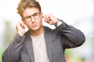 Yüksek sesle müzik gürültü rahatsız ifade parmaklarıyla kulaklarıyla kapsayan izole arka plan üzerinde gözlük takan genç iş adamı. Sağır kavramı.